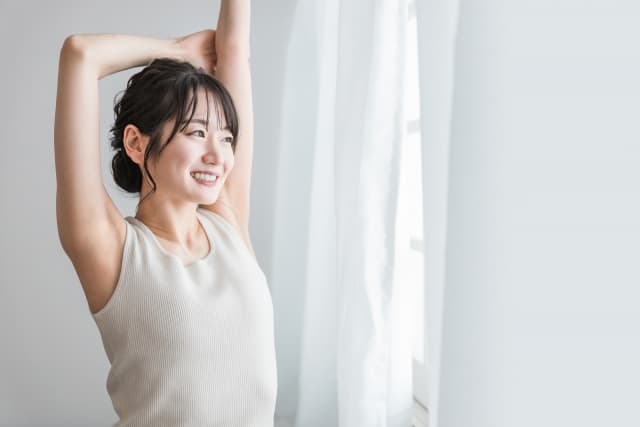 朝の光の中でストレッチする女性