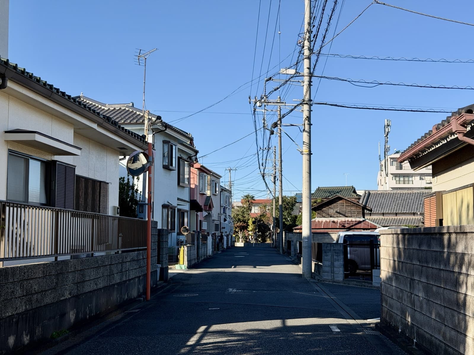 青空の下に続く住宅街の道