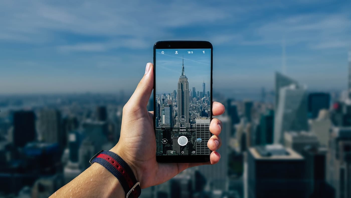 街を背景にスマートフォンを持つ手