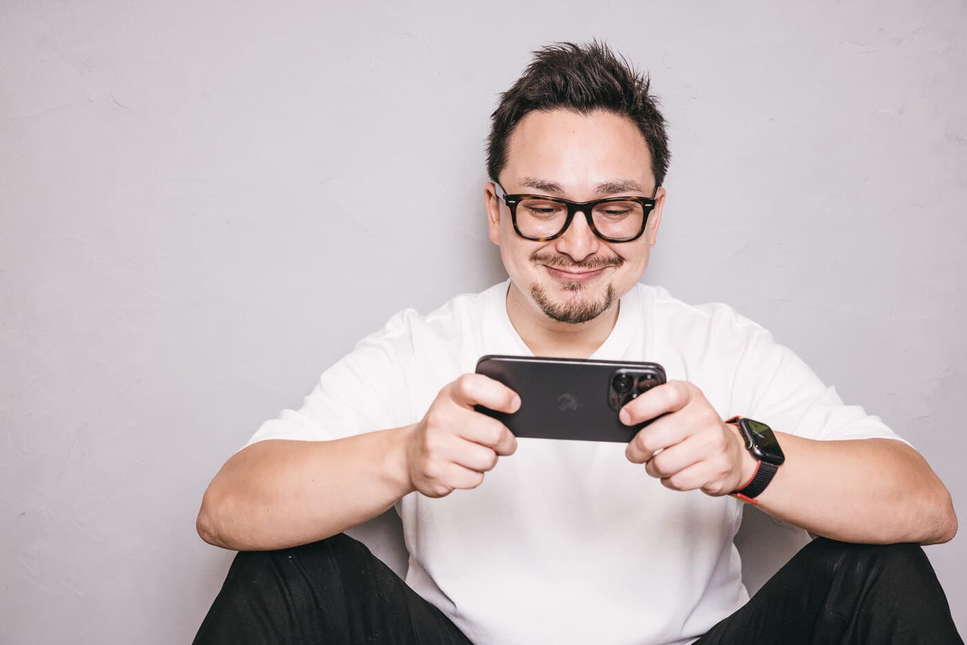 スマートフォンでゲームや動画を楽しむ男性