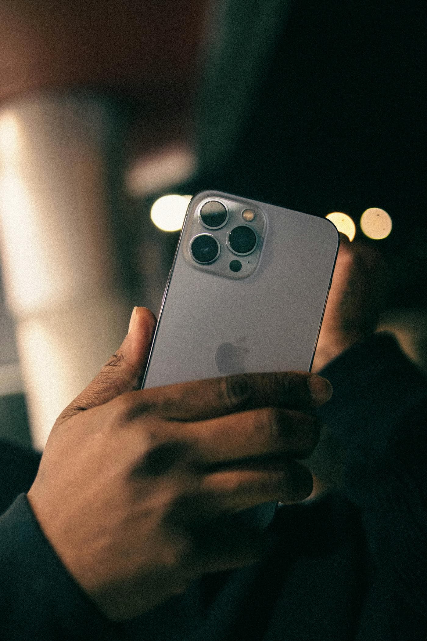暗い場所でスマートフォンを持つ手元
