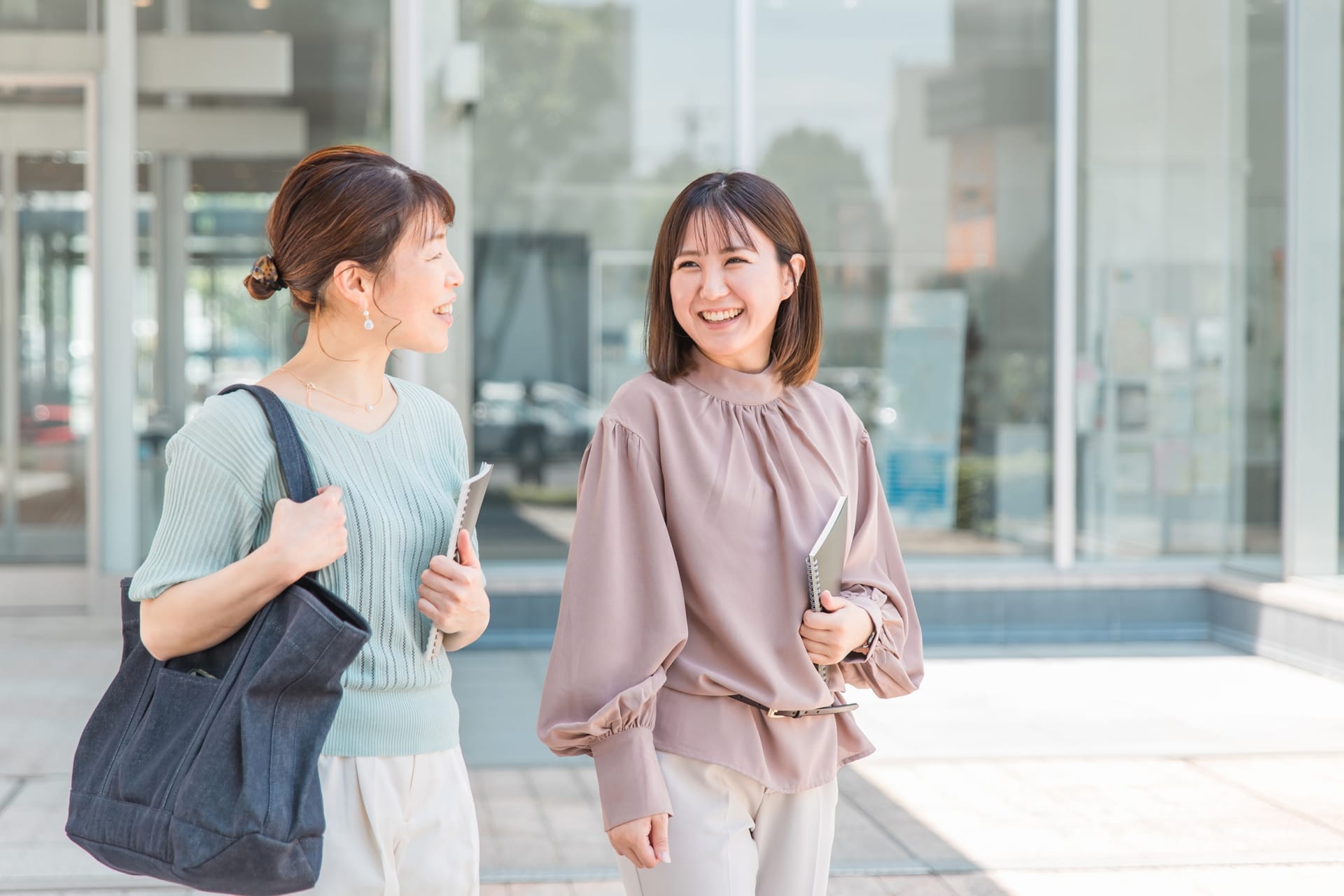 ノートを持って話す社会人女性