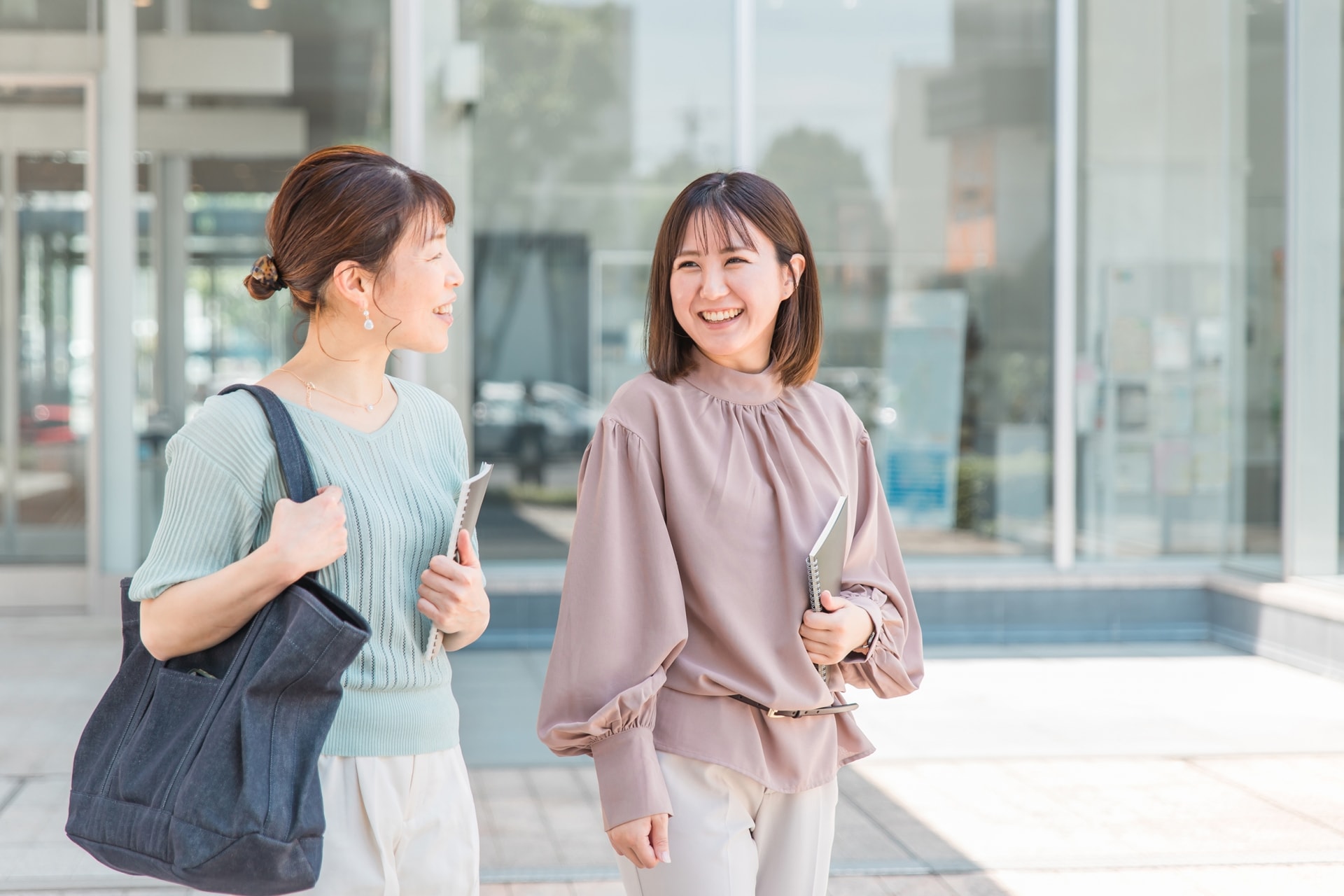 ノートを持って話す社会人女性