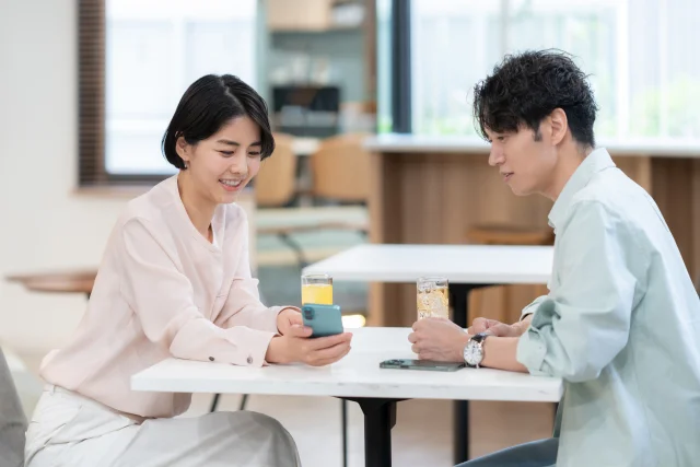 カフェのテーブルで向かい合う二人