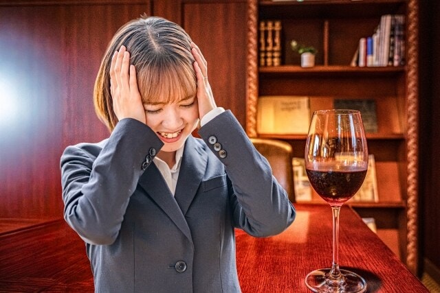 ワインが置かれた席で飲み会に困る女性