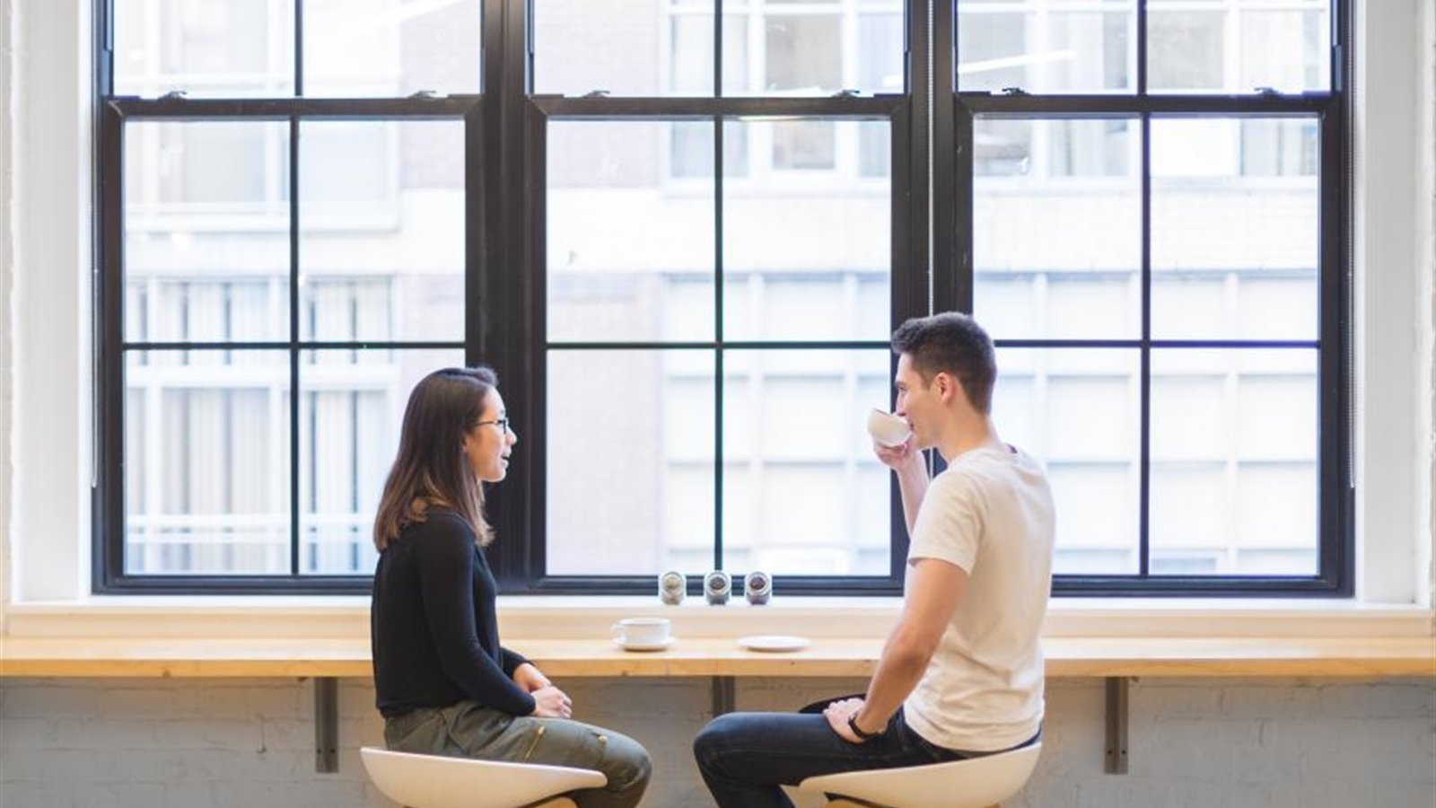 カフェのような場所で向き合って話す男女