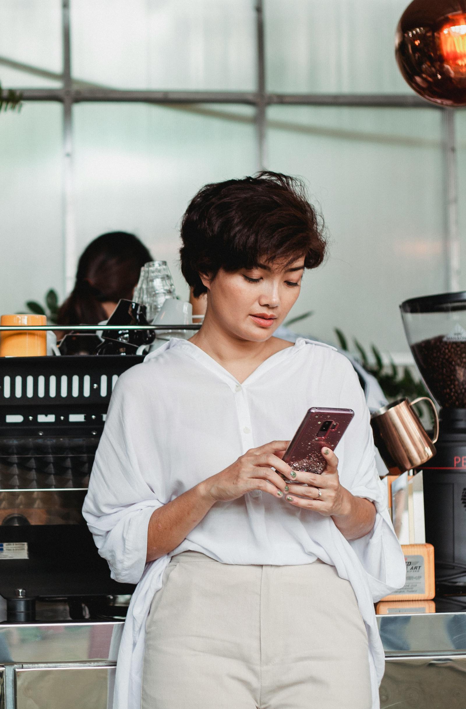 カフェでスマートフォンを確認する女性