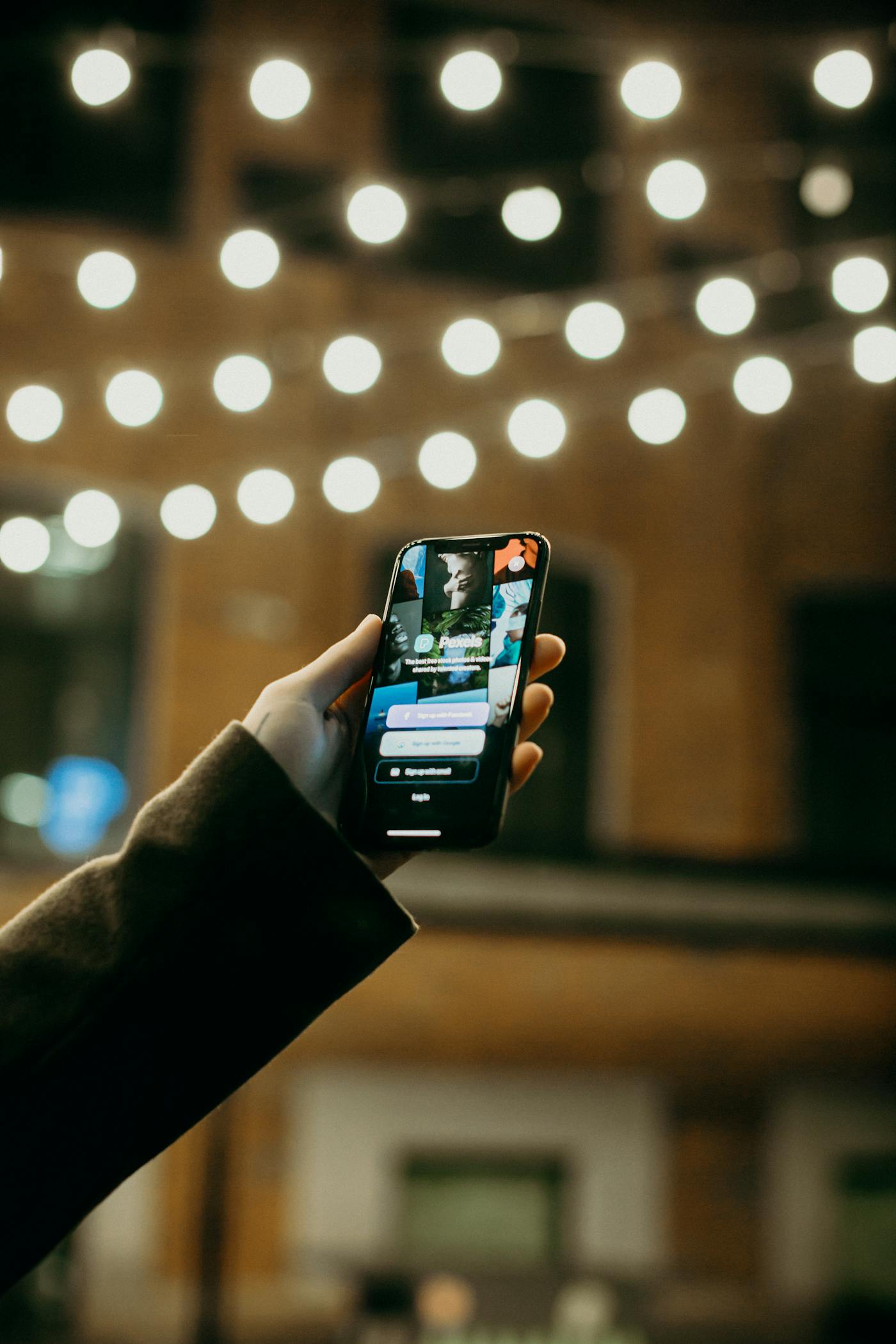 夜の街でスマートフォンを持つ手元