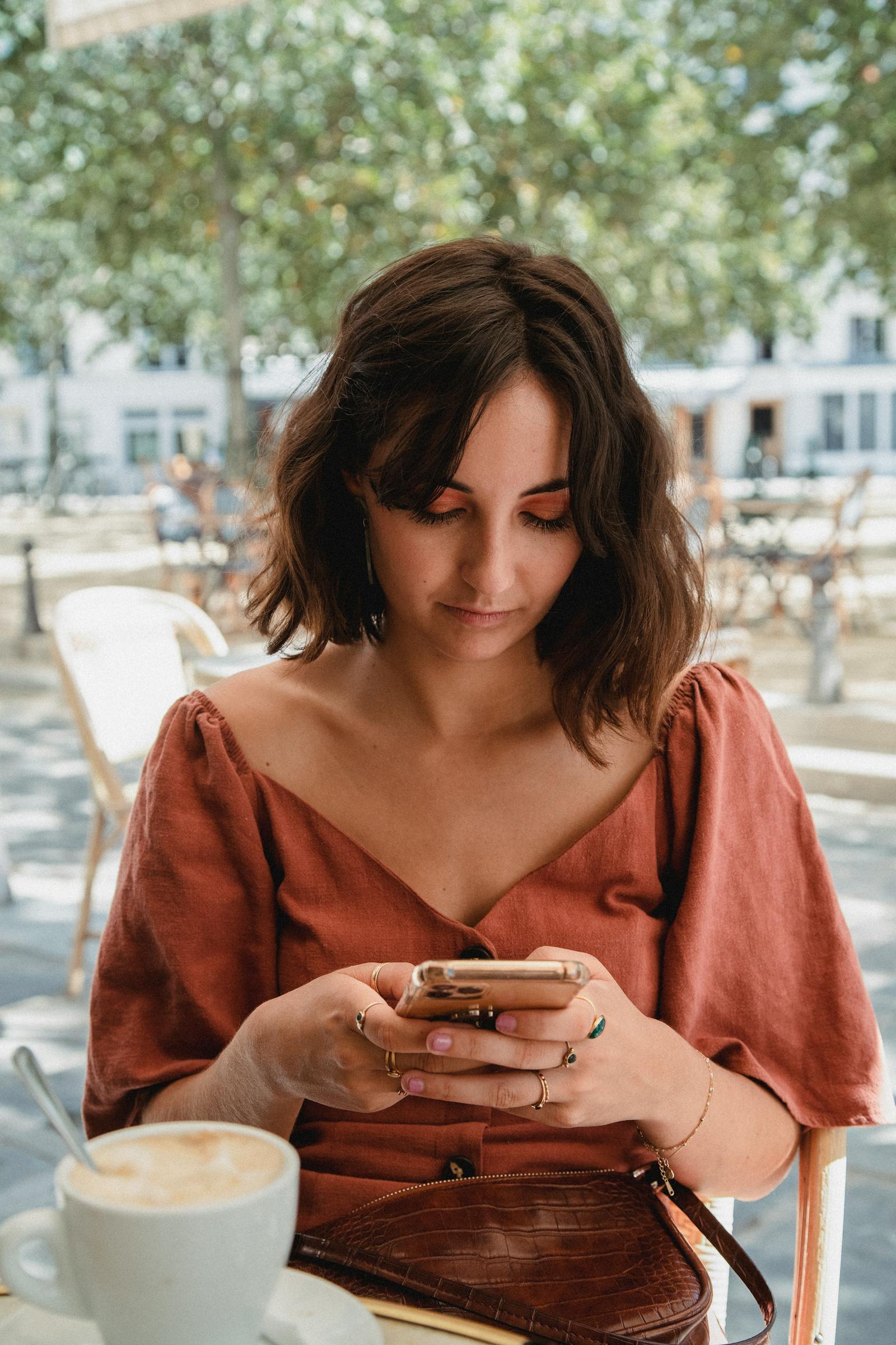 カフェでスマートフォンを見る女性